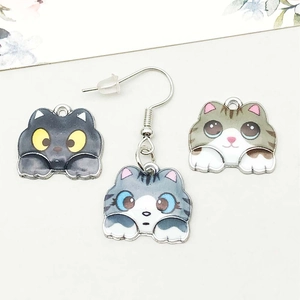 Gros plan de breloques chat en émail coloré avec motifs détaillés pour bijoux DIY