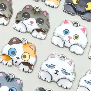 Détail de pendentifs chats colorés en émail pour la création de bijoux et bracelets