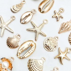 Mix of 16 KC gold ocean themed alloy charms featuring starfish and seashells for DIY jewelry