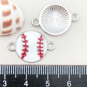 Macro detail of enamel baseball charms showing front stitching and back metal texture