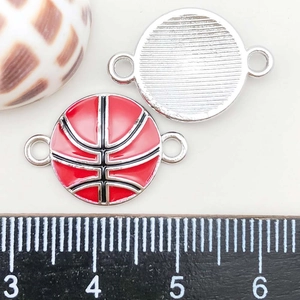 Detailed macro view of double-sided basketball charms with red oil drip finish for DIY jewelry