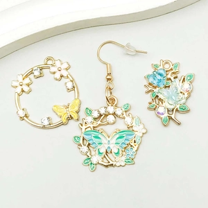 Macro view of colorful enamel butterfly and floral alloy charms with inlaid rhinestones