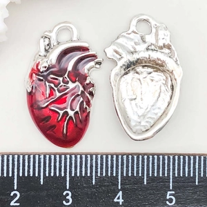 Détail macro de pendentifs cœur anatomique avec émail rouge et finition métal poli