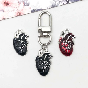 Gros plan de pendentifs cœur anatomique noir et rouge foncé avec finition émail