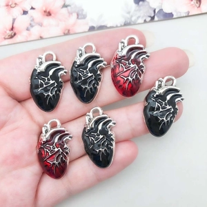 Gros plan de breloques cœur anatomique en émail noir et rouge pour bijoux DIY
