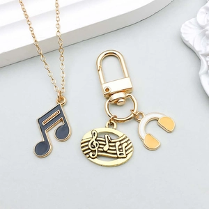 Gros plan détaillé de breloques en émail de notes de musique et casque pour bijoux DIY