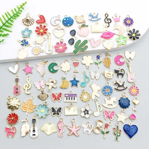 Assorted colorful enamel star and moon charms for DIY jewelry making on white steps
