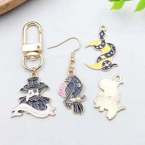 Detailed view of Gothic raven and plague doctor charms with gold plating and enamel