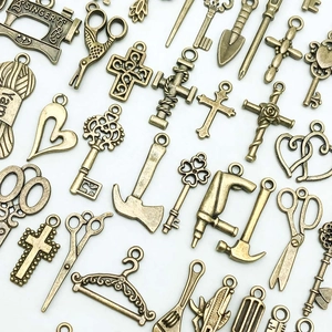 Nahaufnahme von Vintage-Bronze-Anhängern wie Nähmaschinen, Scheren und Schlüssel