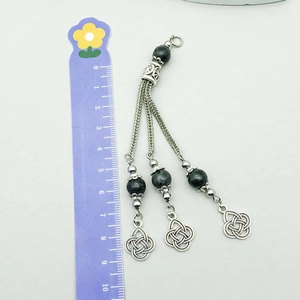 Dettaglio macro di un ciondolo etnico in argento vintage da 10 cm con perline grigie