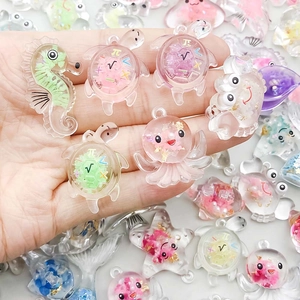 Detalle de colgantes marinos de resina colorida DIY con purpurina y símbolos