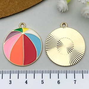 Détail macro du pendentif ballon de plage émaillé 2cm avec dos texturé doré