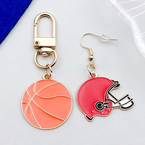Détail du porte-clés de basket et boucles d'oreilles casque de rugby en émail coloré