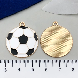 Detail of soccer ball enamel pendant showing black and white patterns and golden metal back