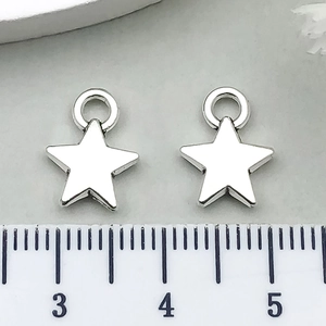 Detailed view of silver star charms with ruler showing 1.2cm size for DIY jewelry