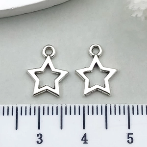 Detail view of silver star charms with a ruler showing approximately 1.2cm size