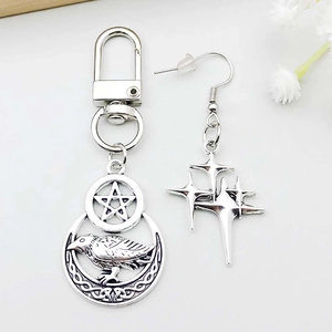 Close-up of gothic silver star and moon charms with intricate Celtic pattern details