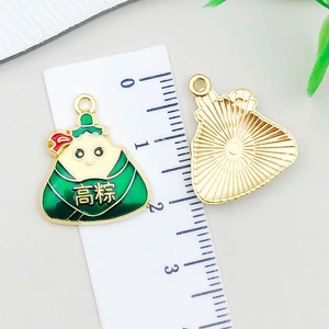 Macro-opname van groene emaille zongzi-hanger met afmetingen voor DIY-sieraden