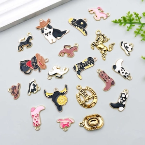 Détail de breloques en émail sur le thème cowboy avec bottes et chevaux miniatures