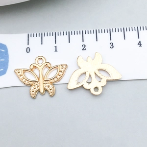 Macro shot of gold butterfly charms with size ruler for DIY jewelry making accessories