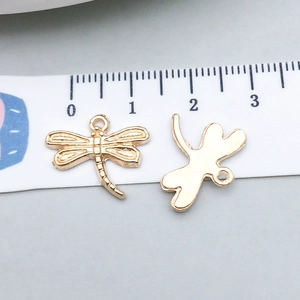 Detailed view of dragonfly-shaped gold pendants with scale showing 1.5cm size