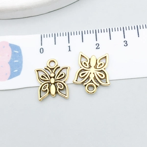 Detail of vintage gold butterfly alloy charms with hollow patterns for DIY jewelry making