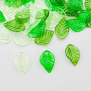 Macro detail of translucent green acrylic leaf charms with delicate vein texture for DIY jewelry
