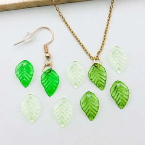 Detailed view of green translucent acrylic leaf pendants with fine vein textures and gold metal