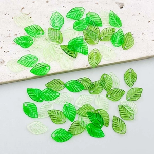 Macro detail of mixed green acrylic leaf pendants with translucent veins for DIY jewelry