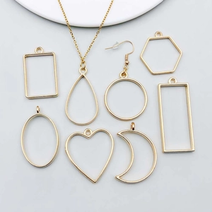 Detailed flat lay of geometric KC gold moon and heart pendants for DIY jewelry making