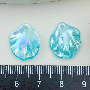 Close-up of iridescent acrylic cabbage leaf charms for DIY jewelry making with ruler