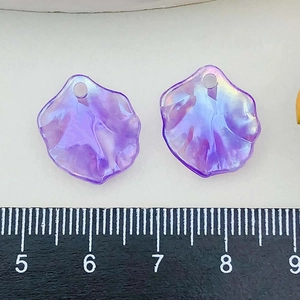 Macro view of colorful purple acrylic cabbage leaf pendants with ruler for size scale