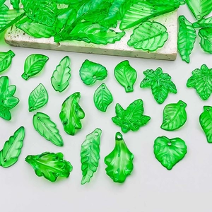 Macro shot of green translucent acrylic leaf charms with veins and DIY holes
