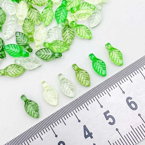 Macro shot of 10mm green acrylic leaf pendants showing vein details and size scale