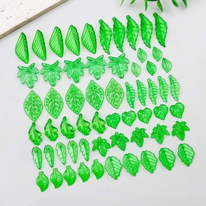 Detailed macro view of assorted green acrylic leaf pendants with intricate vein patterns