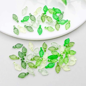 Detailed view of green acrylic leaf charms with realistic vein textures for DIY jewelry