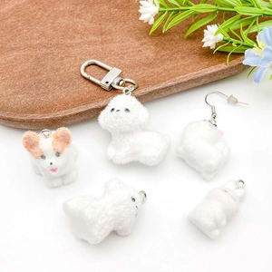 Detailed view of DIY flocked resin dog charms used as keychains and earrings