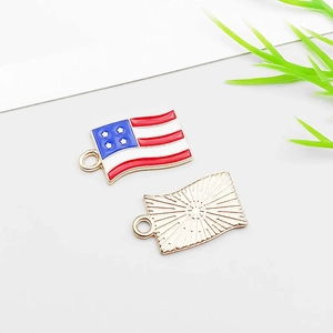 Macro shot of American flag alloy charms showing enameled front and textured gold back