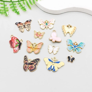 Vue détaillée de pendentifs papillons colorés en émail avec base en alliage doré