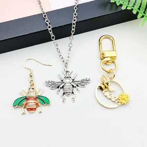 Flachbild von Bienen-Schmuckset mit Emaille-Ohrringen und goldenem Queen-Schlüsselbund