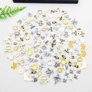 Makro-Detail von Bienen-, Waben- und Gänseblümchen-Anhängern für DIY-Schmuck