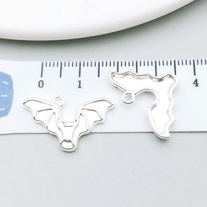 Macro shot of silver bat charms showing detailed wing textures for DIY jewelry making