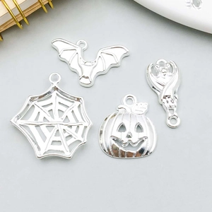 Close-up of silver Halloween charms including spider webs and bat pendants for DIY jewelry