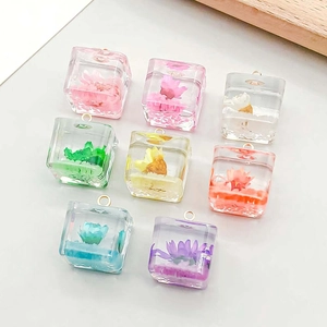 Close-up of square resin pendants with real dried flowers and metal hanging loops