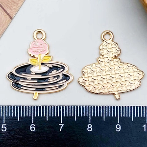 Detail view of pink enamel phonograph charm with rose design and gold metal back