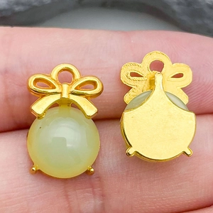 Close-up of green glass bow pendant showing front detail and gold metal backing