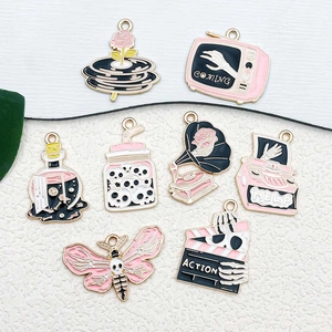 Detailed macro view of gothic pink enamel charms including skull hand and typewriter