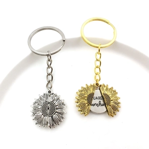 Detail of opening sunflower keychain with You Are My Sunshine engraving in gold and silver