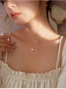 Detalle del collar de plata s925 con colgante de sol y olas en el cuello de una mujer