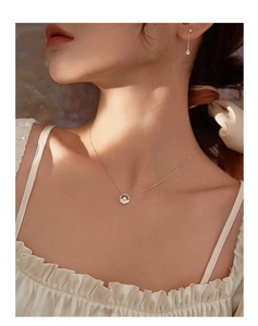 Vista detallada del collar de estrella de plata y pendientes largos en una modelo